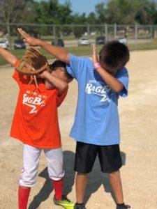 two boys in baseball uniforms dabbing